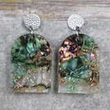 A pair of one of a kind arch shaped recycled acrylic earrings with green and pink design titled 'Enchanted Forest' and stainless steel toppers. Pair 103-05