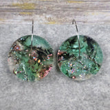 A pair of one of a kind disc shaped recycled acrylic earrings on stainless steel hoops with green and pink acrylics titled 'Enchanted Forest'. Pair 03-09
