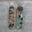 A pair of one of a kind long oval shaped recycled acrylic earrings with green and pink design titled 'Enchanted Forest' and stainless steel toppers. Pair 103-13