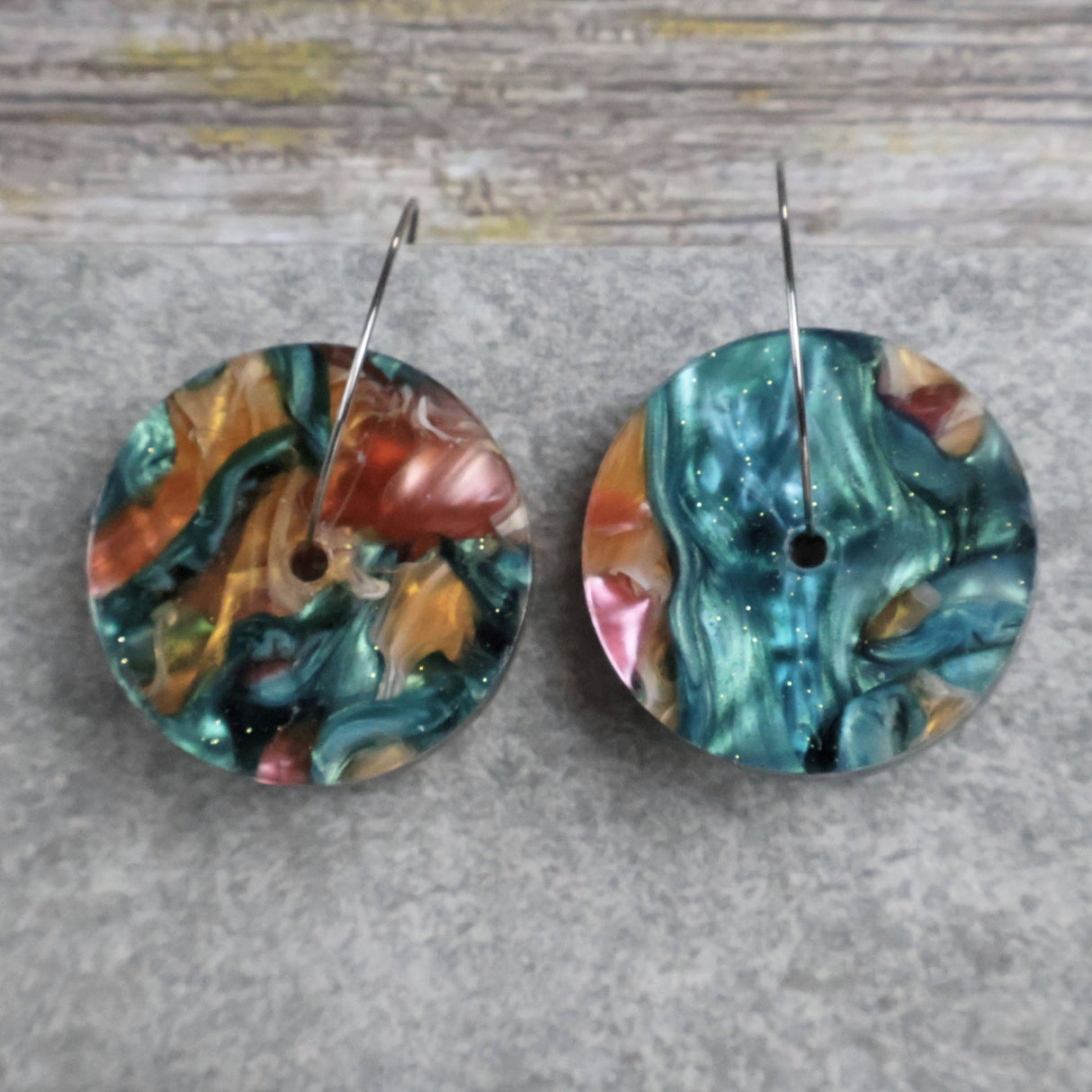 Pair of one of a kind disc acrylic earrings on stainless steel hoops with multicolored design titled 'Sunset Reef'. Pair 106-11