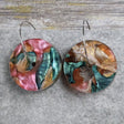Pair of one of a kind disc acrylic earrings on stainless steel hoops with multicolored design titled 'Sunset Reef'. Pair 106-012