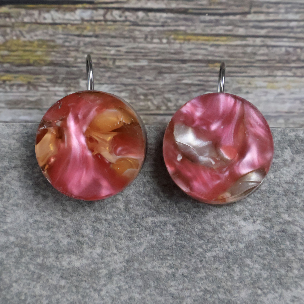 A pair of one of a kind round recycled acrylic earrings with stainless steel french hooks and multicolored design titled 'Sunset Reef'. Pair 106-14