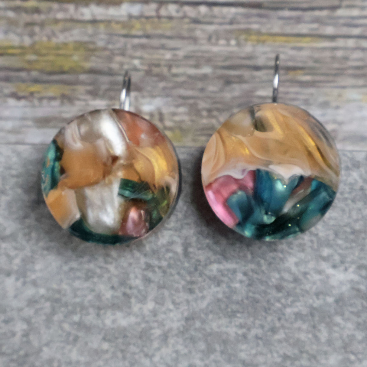 
A pair of one of a kind round recycled acrylic earrings with stainless steel french hooks and multicolored design titled 'Sunset Reef'. Pair 106-17