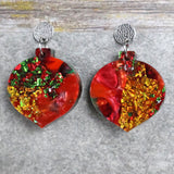 A pair of one of a kind recycled acrylic Christmas bauble earrings with stainless steel toppers, featuring a red, green and gold acrylic design. Pair 107-04