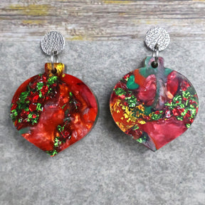 A pair of one of a kind recycled acrylic Christmas bauble earrings with stainless steel toppers, featuring a red, green and gold acrylic design. Pair 107-05