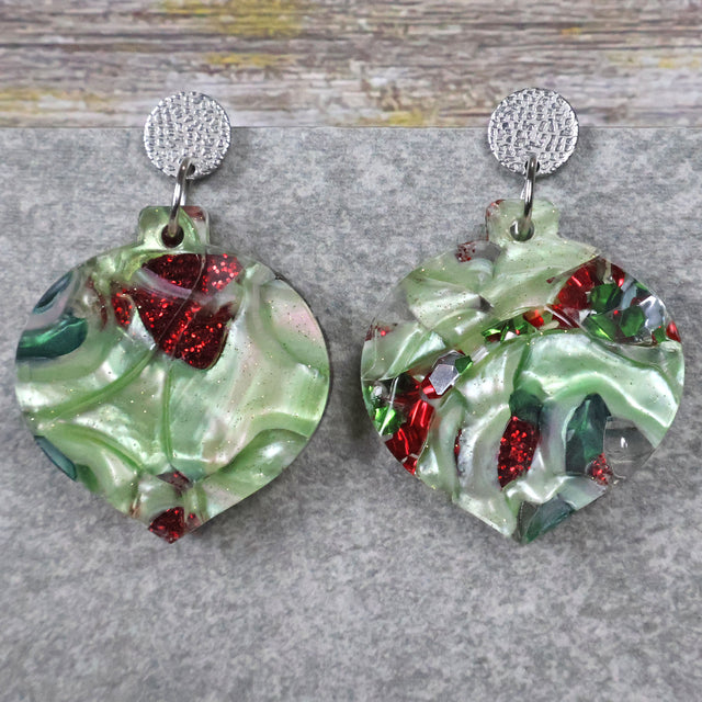 A pair of one of a kind recycled acrylic Christmas bauble earrings with stainless steel toppers, featuring a red and green acrylic design. Pair 109-03