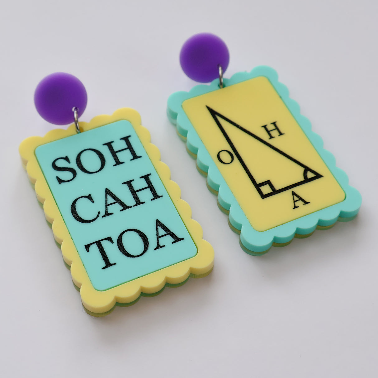 Asymmetrical blue and yellow earrings with 'SOH CAH TOA' and trigonometric triangle design with purple toppers