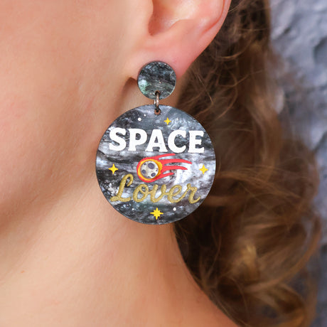 Earring with 'SPACE Lover' text worn by a person