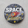 Circular acrylic brooch with 'Space Lover' text and space-themed design with a meteor