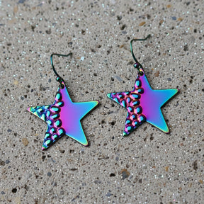 Star-shaped earrings with a metallic, iridescent finish on a gray background