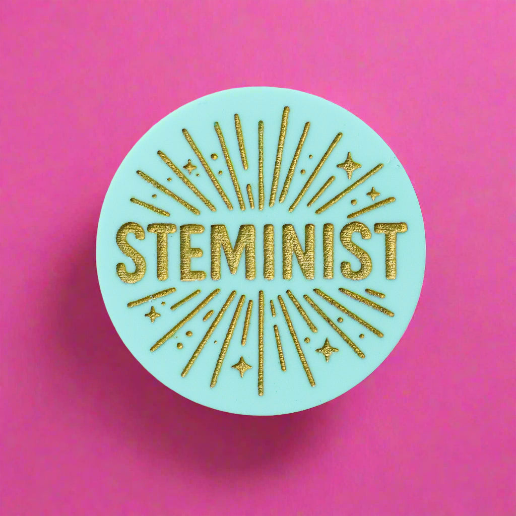 Round teal acrylic brooch with 'STEMINIST' in gold text