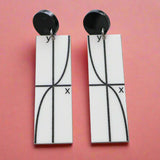 Pair of black and white earrings with tan graph design