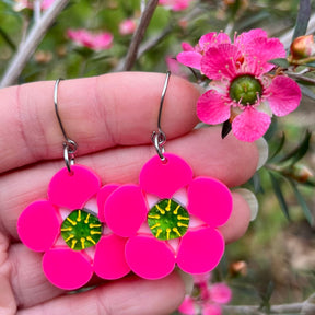 Tea tree Merinda flower earrings next to actual flowers of the same name.