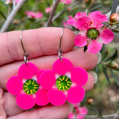Tea tree Merinda flower earrings next to actual flowers of the same name.