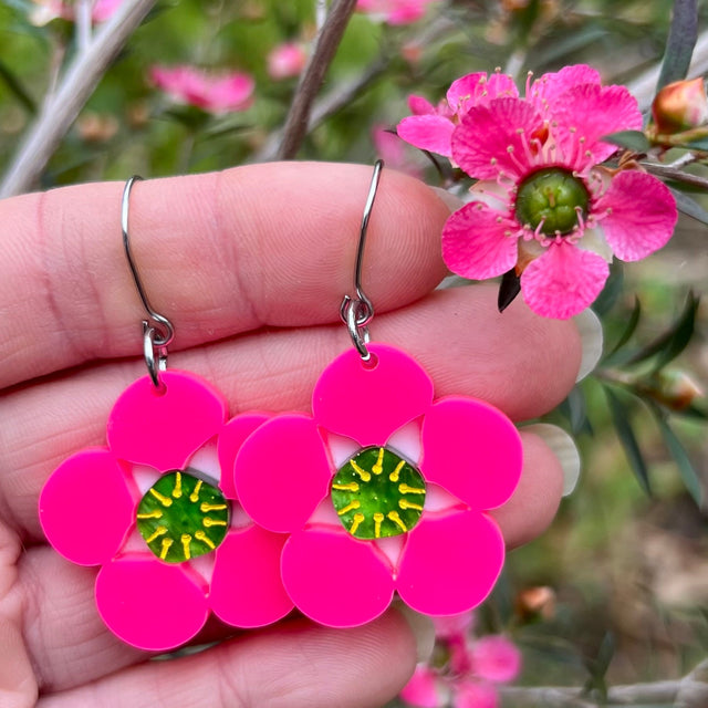 Tea tree Merinda flower earrings next to actual flowers of the same name.