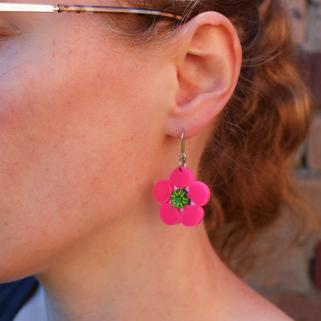 Bright pink Tee tree merinda earrings being modelled. Earrings hang on French hooks. 