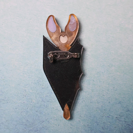 The back view of a vampire bat brooch, showing the stainless steel brooch pin with rolling clasp. 