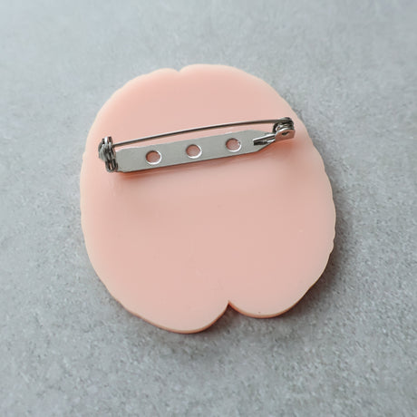 The back view of an acrylic brain brooch showing stainless steel brooch back and rolling clasp