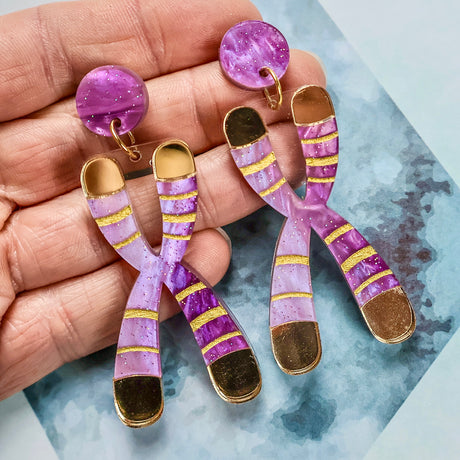 Close-up detail of Chromosome Earrings highlighting metallic gold hand-painted telomere accents on swirly acrylic