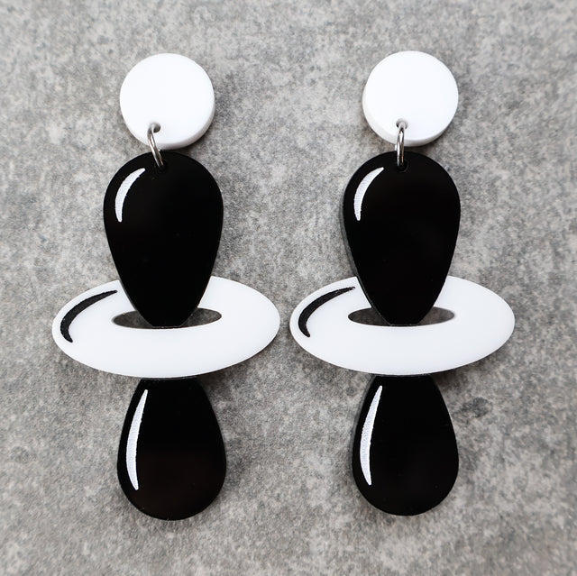 Black and white laser cut acrylic earrings depicting the dz2 electron orbitals. 