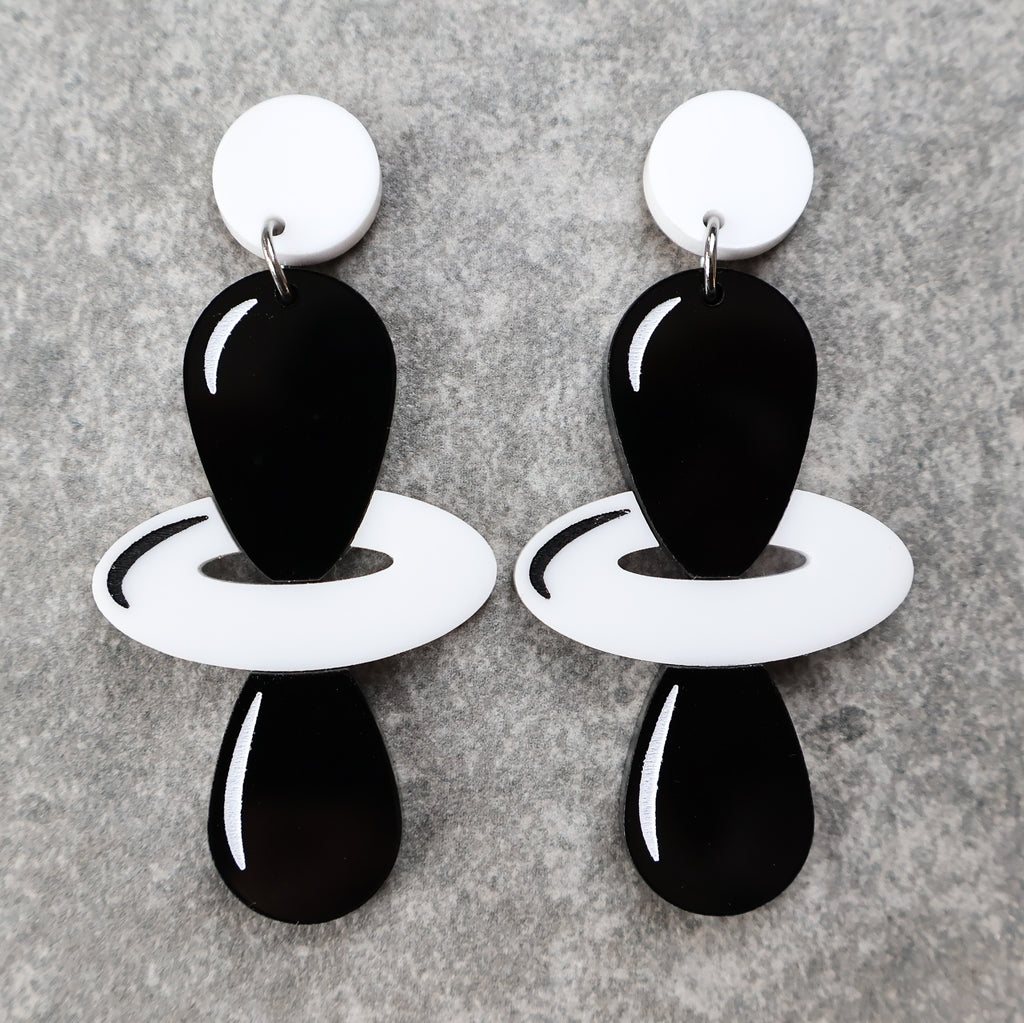 Black and white laser cut acrylic earrings depicting the dz2 electron orbitals. 