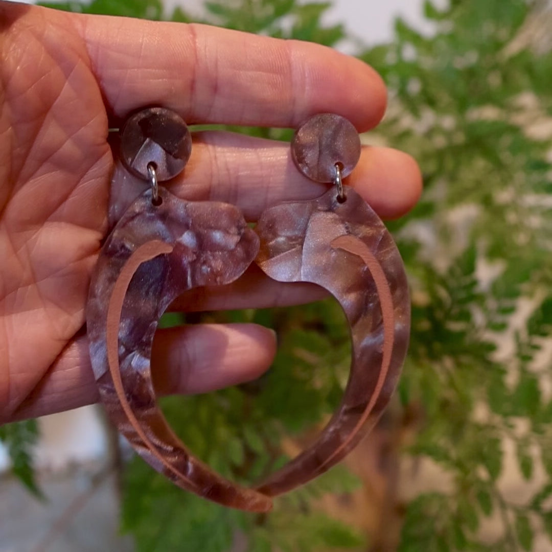 Closeup Video of Acrylic velociraptor claw earrings by Oh Pluto