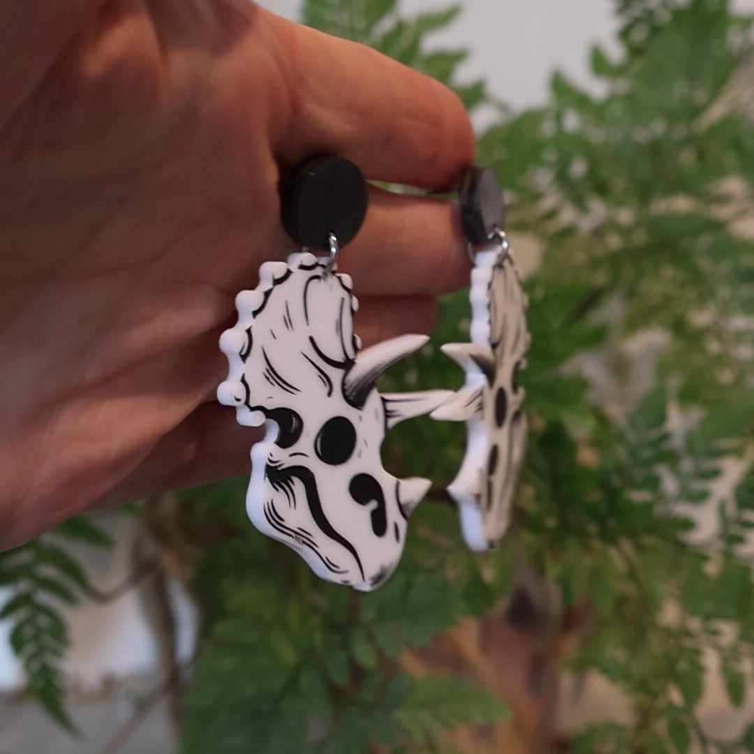 Closeup Video of Acrylic triceratops skull earrings by Oh Pluto