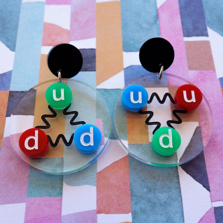 Laser cut acrylic quark earrings, , with green, red and blue up and down quarks, and hanging from black earring toppers.