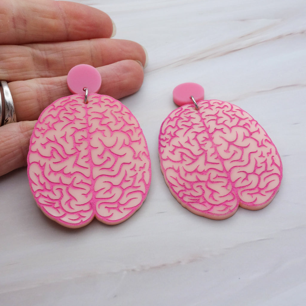 A pair of realistic looking brain earrings in light pink acrylic, with hot pink painted details. Laser cut from acrylic.