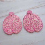 A pair of realistic looking brain earrings in light pink acrylic, with hot pink painted details. Laser cut from acrylic.