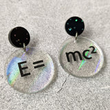 E =mc2 earrings, with black text engraved into holographic effect acrylic discs. Equation bridges both earrings. Black glitter earring toppers. Alternative view.