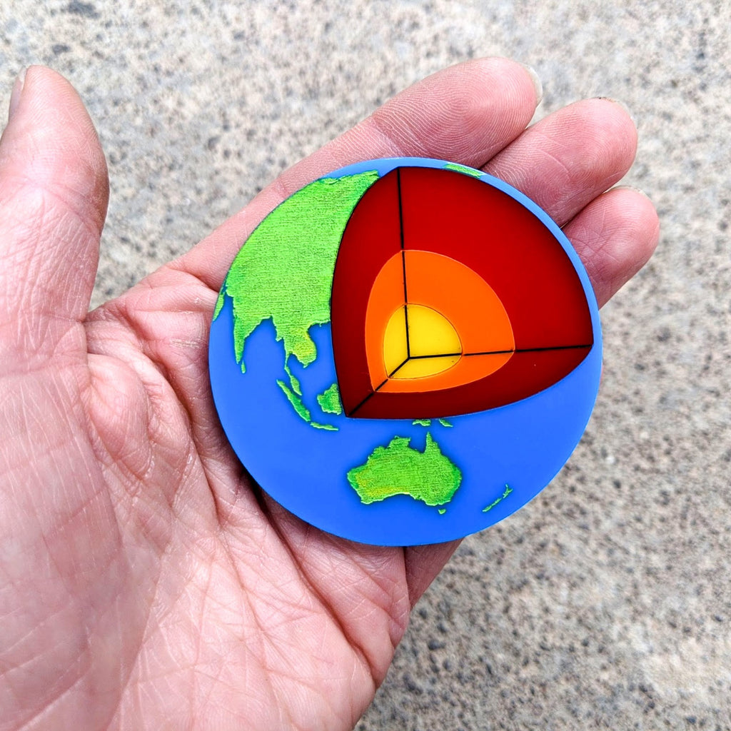 Laser Cut Acrylic Planet Earth Brooch with Core Cutout in hand