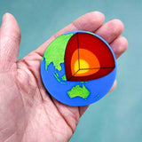 Laser Cut Acrylic Planet Earth Brooch with Core Cutout in hand