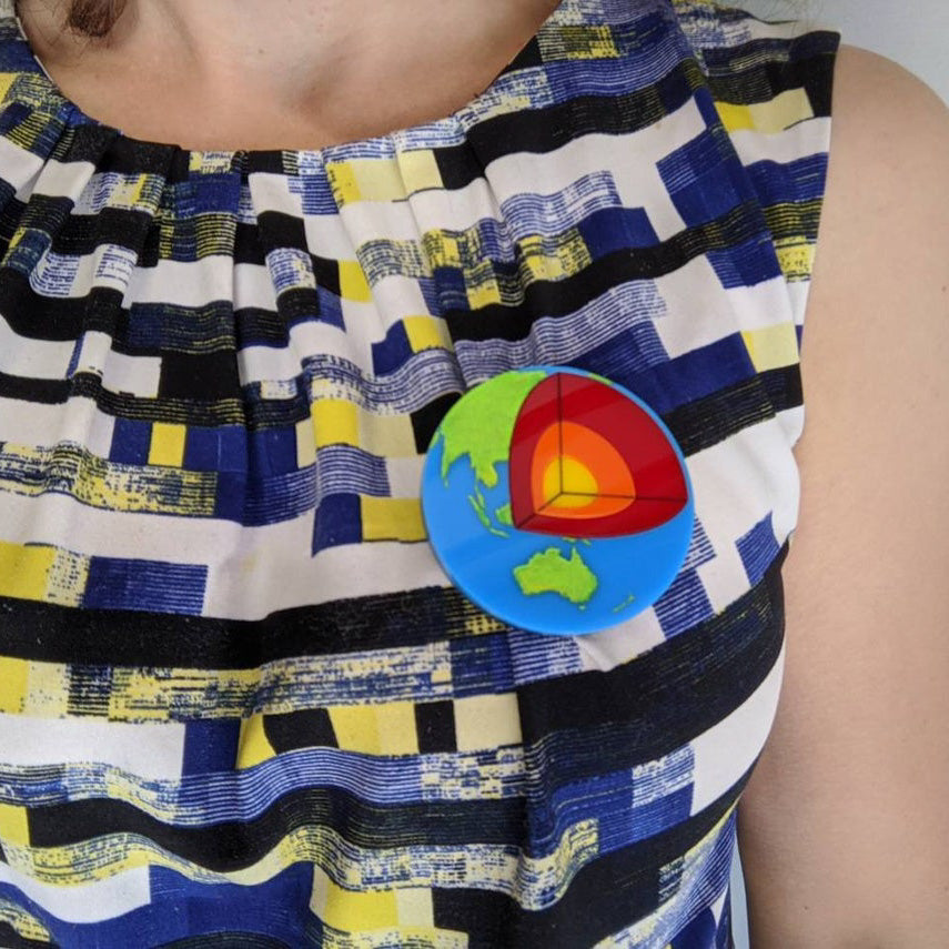 Laser Cut Acrylic Planet Earth Brooch with Core Cutout being worn. 