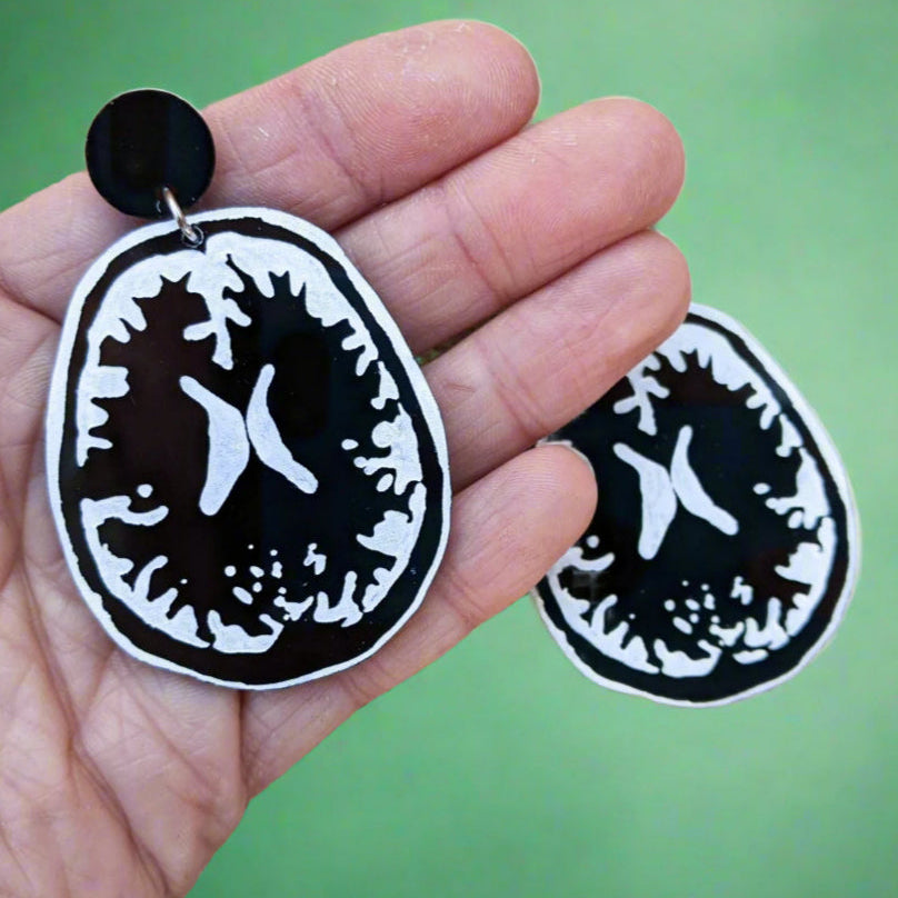 Laser Cut Acrylic Brain MRI Earrings in Black and White. In hand for scale.