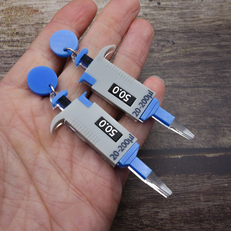 Grey and blue micropipette earrings laser cut and handpainted from acrylic. They hang from blue earring toppers.