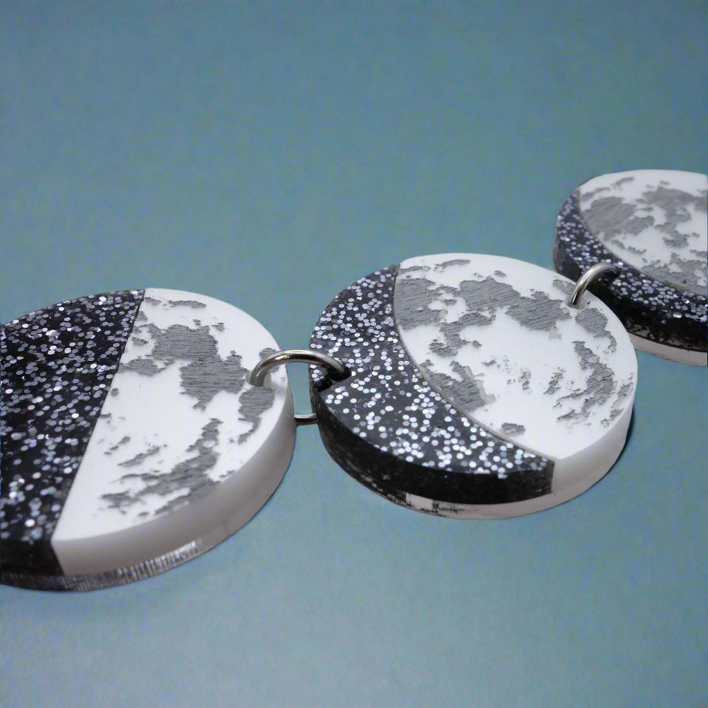 Close-up view of acrylic moon phase necklace