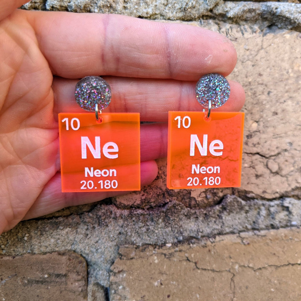 Laser Cut Acrylic Neon Periodic Table Earrings. Clear Orange/Pink Acrylic with silver glitter earring toppers. 