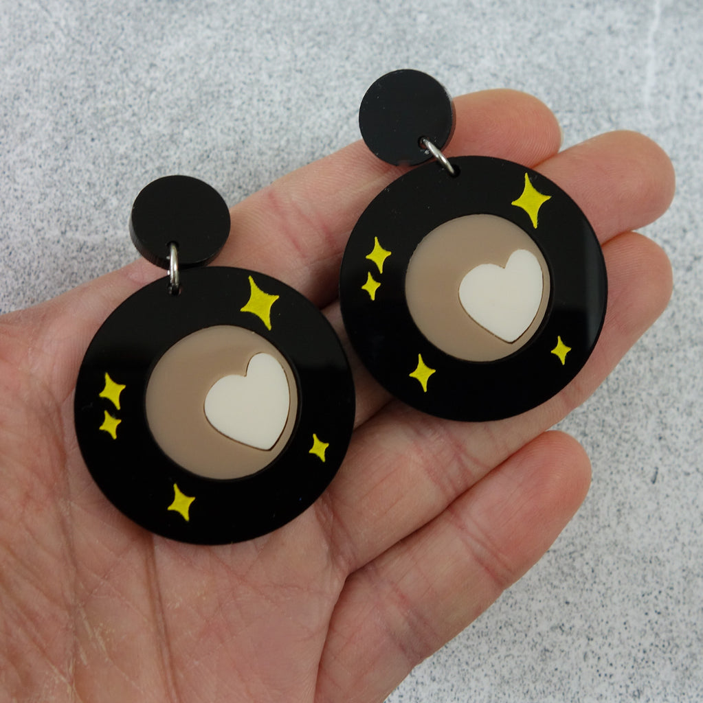 Laser cut acrylic Pluto Earrings showing Tombaugh Regio. 