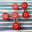 Laser cut acrylic ozone molecule studs, with red oxygen atoms and black molecular bonds.
