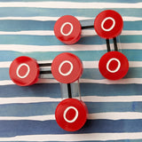Laser cut acrylic ozone molecule studs, with red oxygen atoms and black molecular bonds.