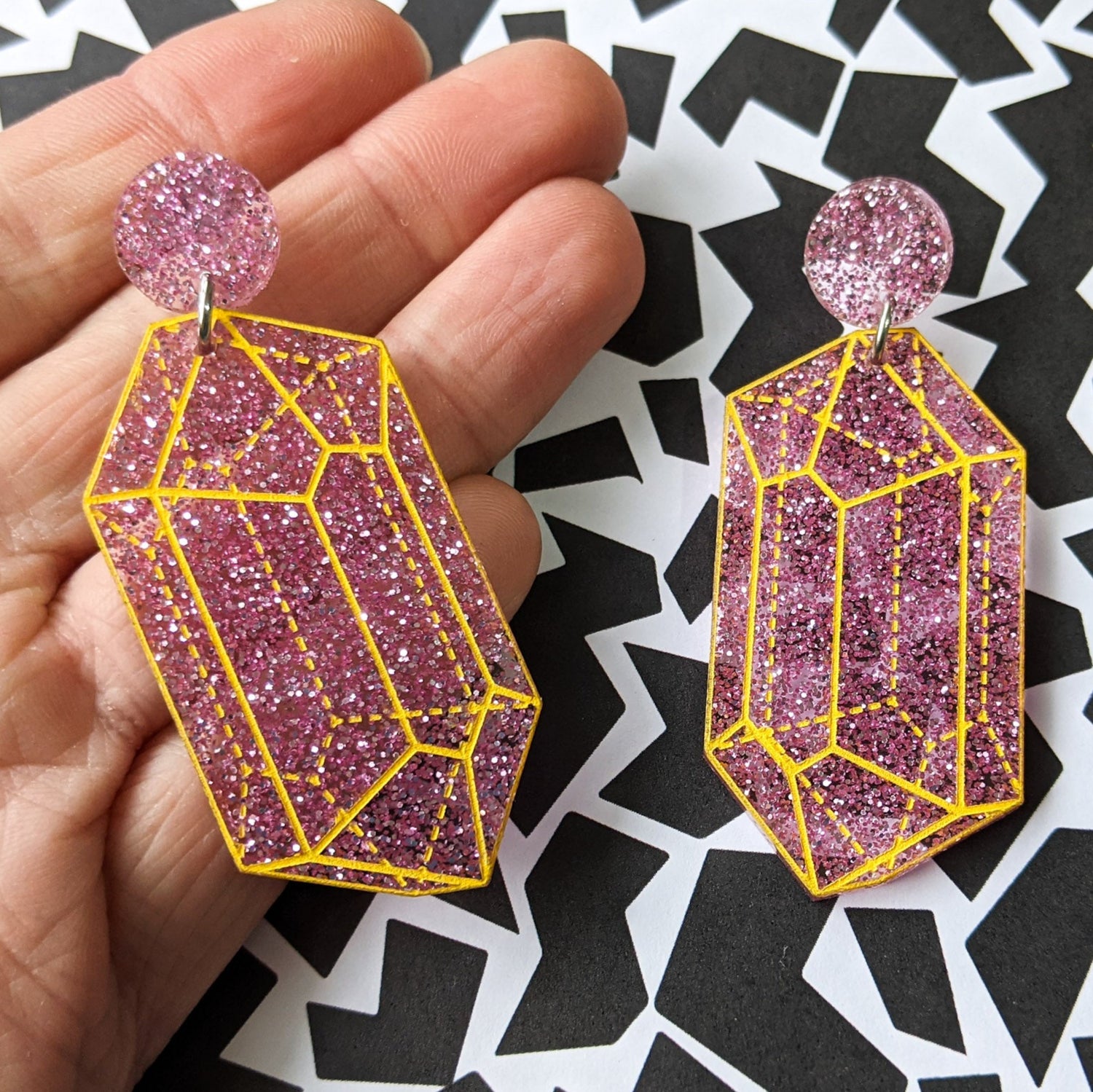 Pink glitter crysalline structure earrings with yellow handpainted outlines of the crystal structure.  Second view.