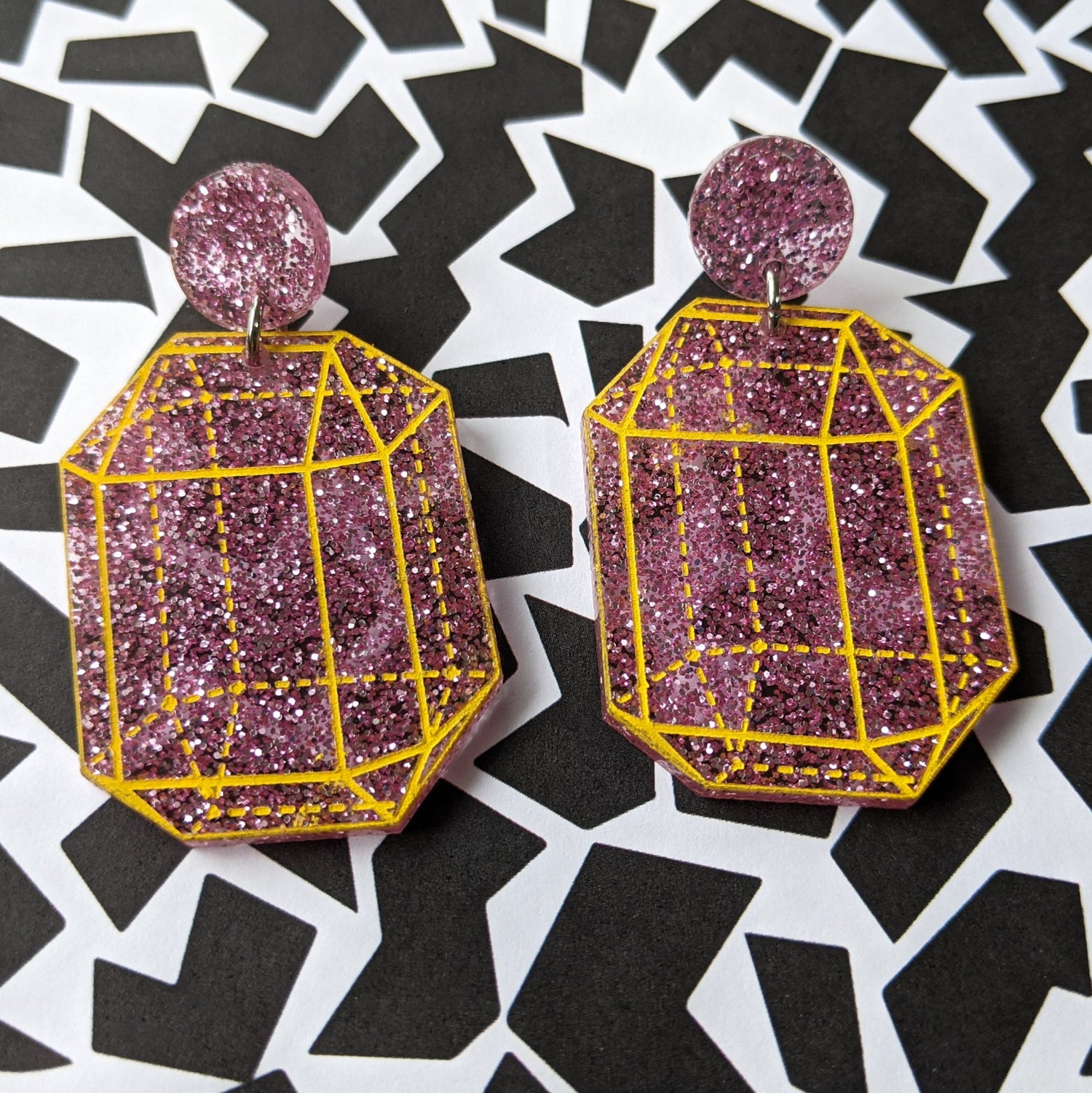 Pink glitter crysalline structure earrings with yellow handpainted outlines of the crystal structure. Design 2.