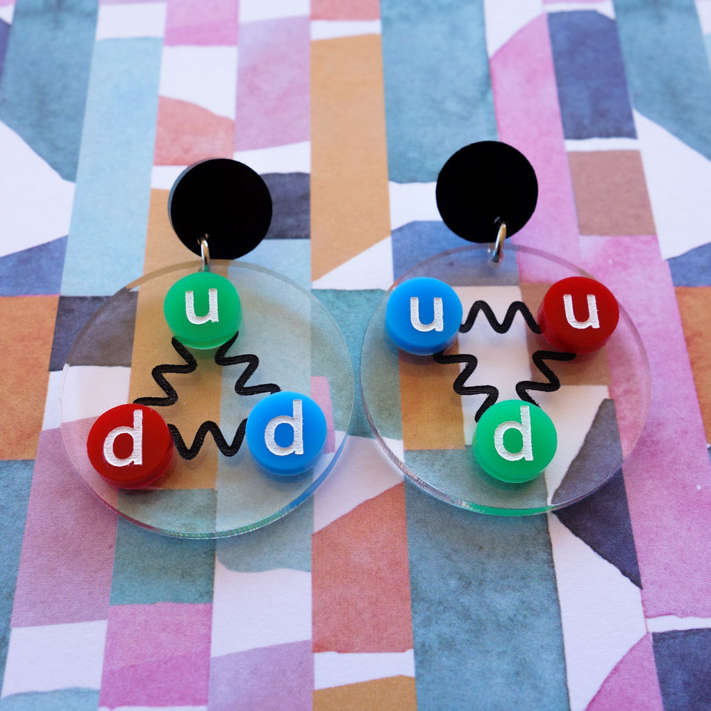 Laser cut acrylic quark earrings, , with green, red and blue up and down quarks, and hanging from black earring toppers.