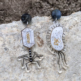 Asymmetrical Bacteria and Virus Laser Cut Acrylic Earrings closeup against concrete background