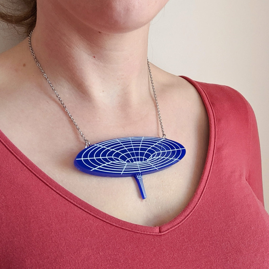 Dark blue black hole acrylic necklace being modelled. For Astronomy lovers. 